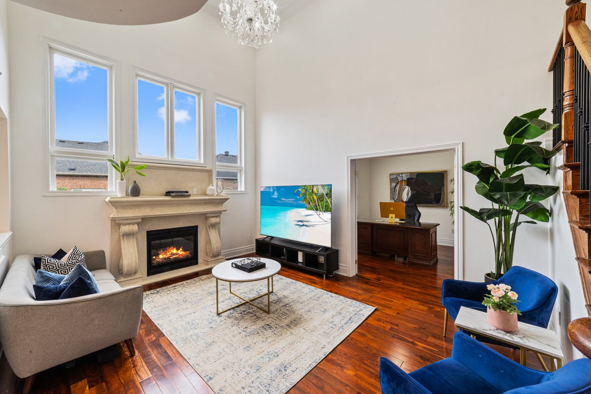 A well staged living room with a lit fireplace and tidy furniture