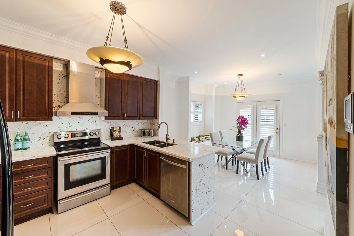 A bright kitchen with a large island opening onto a dining area