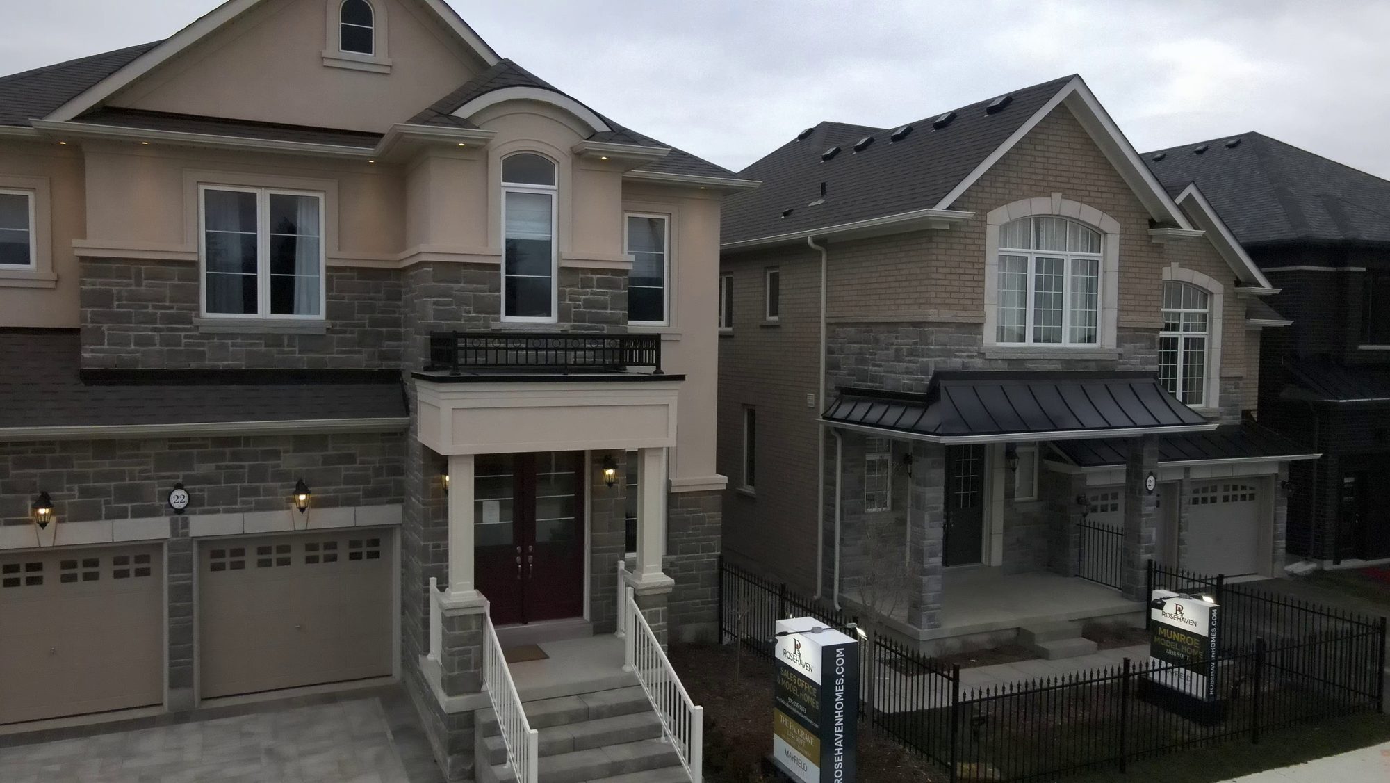 Newly built brick and stone houses with attached garages on a fresh street