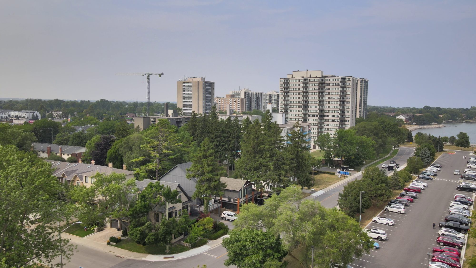 Apartment towers standing above trees and low-rise streets near the water
