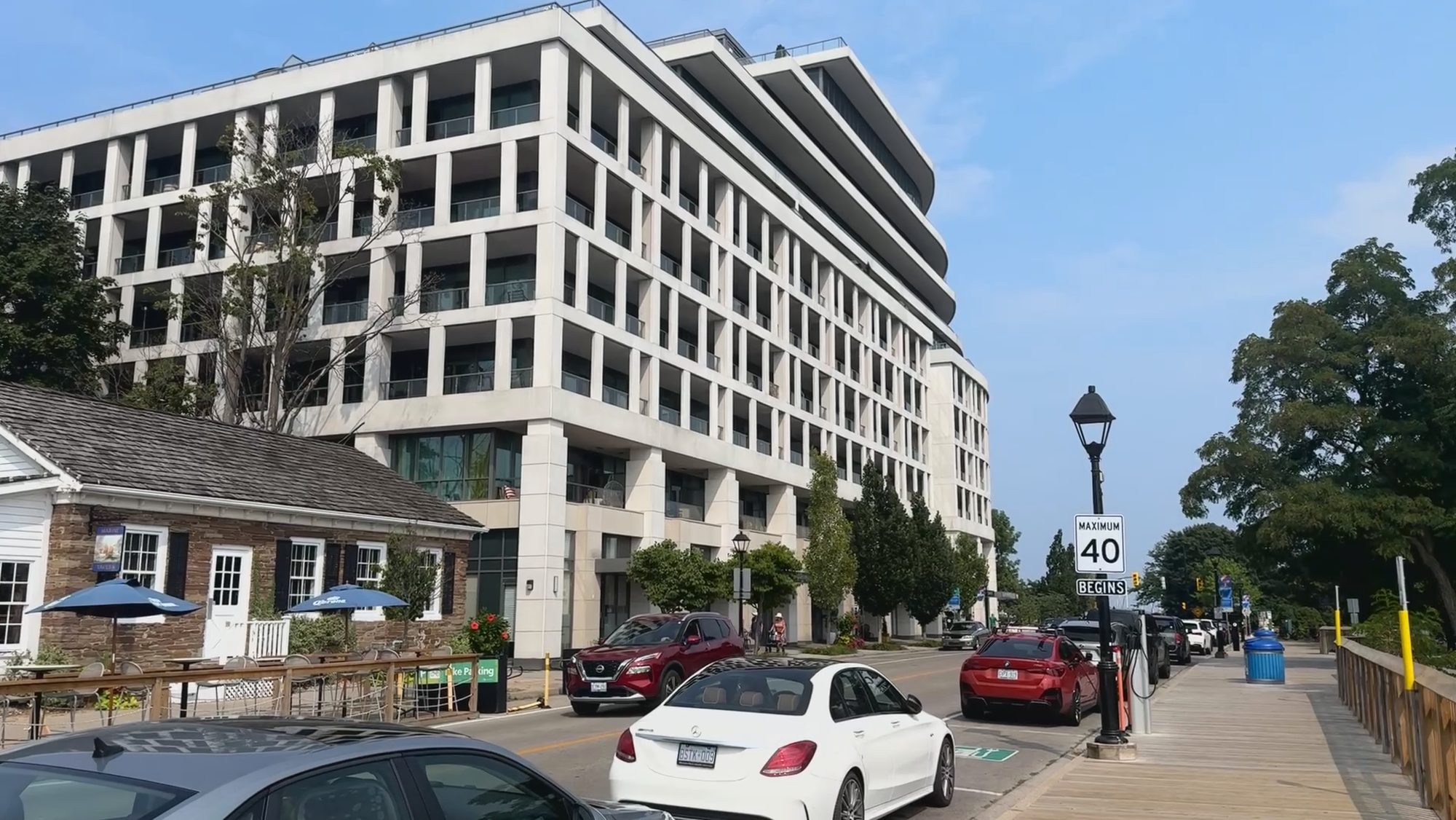A modern mid-rise building meeting an older street on a bright day
