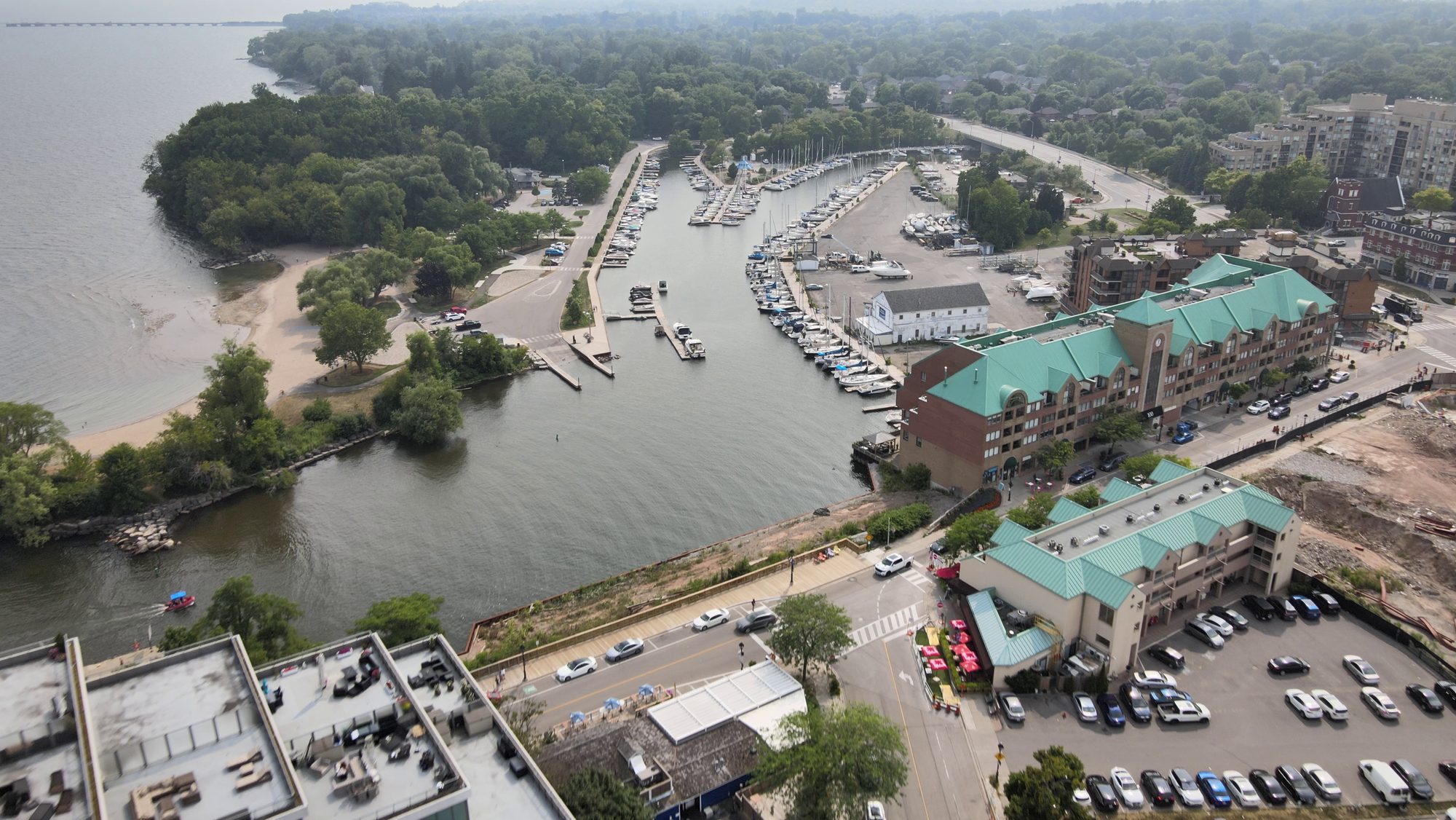 A harbour and marina on Lake Ontario with wooded shoreline, from the air