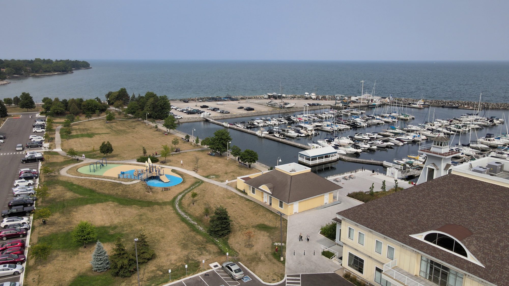 A lakeside park and playground beside a marina full of moored boats