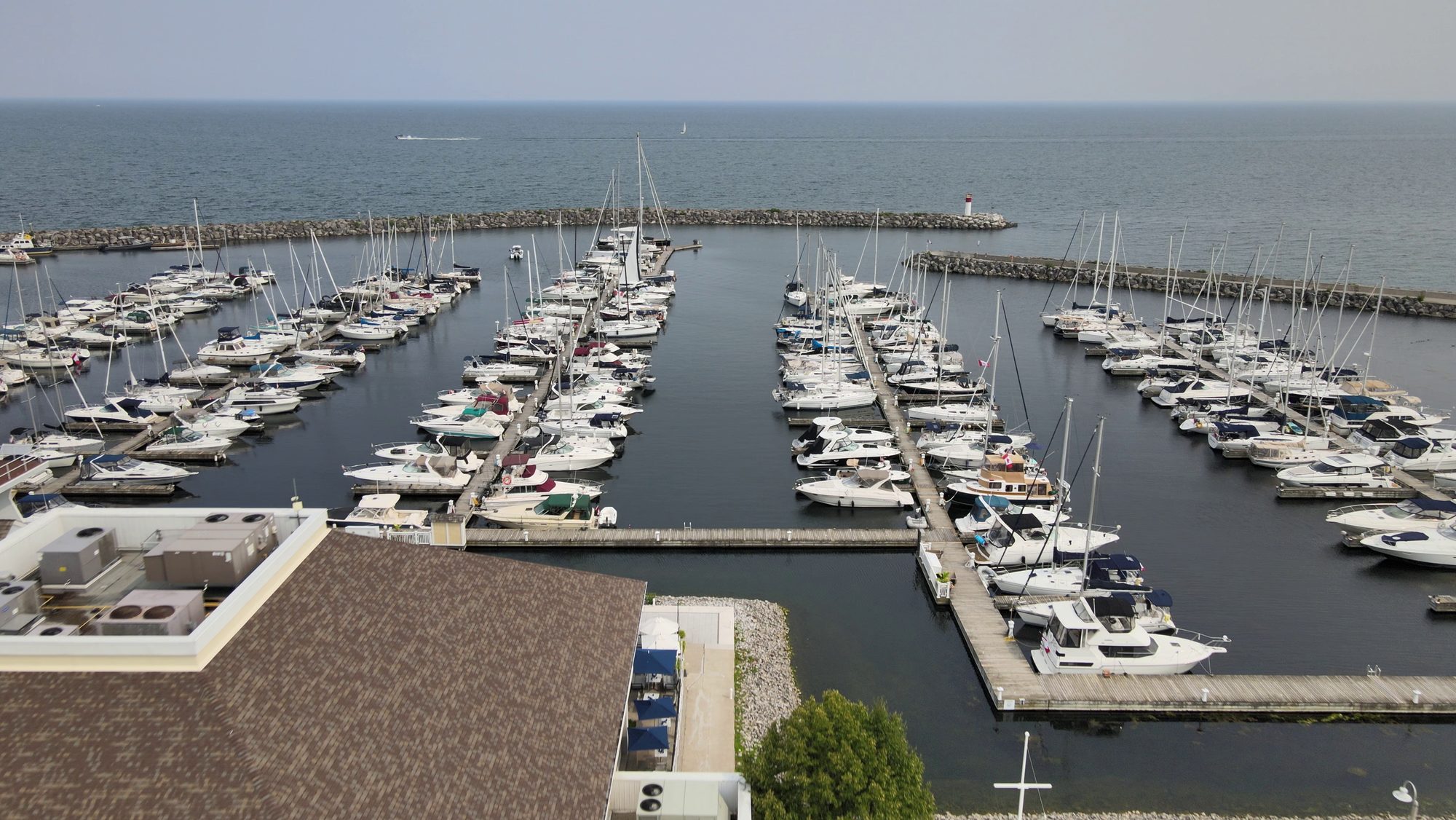 Sailboats and cruisers moored in a breakwater marina on the lake